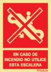 Señal de prohibición del uso de escaleras mecánicas y con el texto EN CASO DE INCENDIO NO UTILICE ESTA ESCALERA