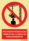 Señal de prohibición con el pictograma y texto de prohibido permanecer debajo la grúa